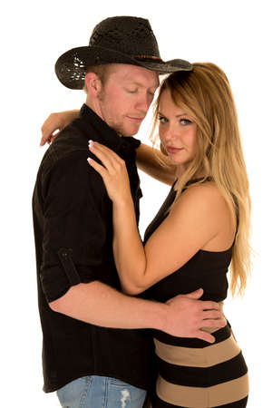 a cowboy looking down holding on to his woman.の写真素材