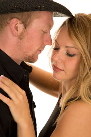 a close up of a cowboy with his woman her eyes are closed.の写真素材