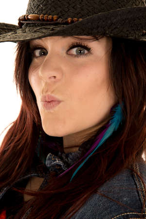 a close picture of a woman with her lips puckered in her cowgirl hat.の写真素材