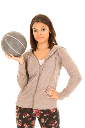 A woman in her fitness clothes holding on to a medicine ball with a serious expression.の写真素材