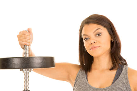 a woman with a serious expression on her face with her hand on a bar with a weights.の写真素材