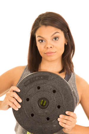 A woman with a serious expression on her face, with a weight in her hands.の写真素材