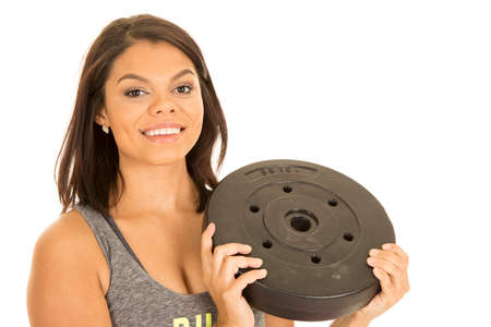 A woman with a smile on her face, holding on to her weight.の写真素材