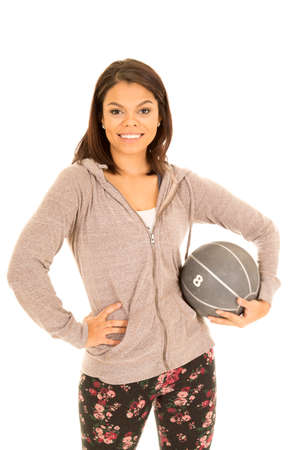 A woman with a big smile on her face, holding on to her medicine ball.の写真素材