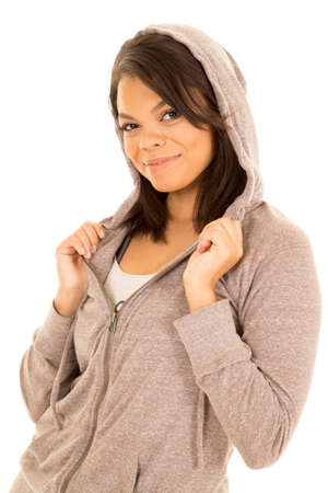 A woman with a big smile on her lips holding on to her jacket.の写真素材