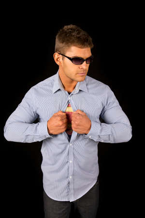 A man in his business shirt playing a hero opening up his shirt.の写真素材