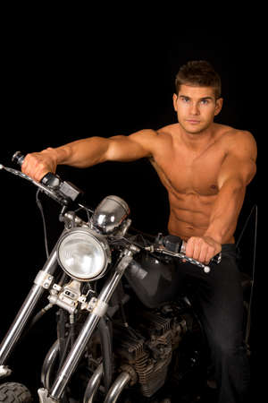 A man sitting on his motorcycle with out a shirt on, with a serious expression.の写真素材