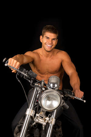 A man with a smile on his face, sitting on his motorcycle.の写真素材