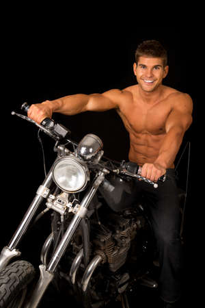 A man sitting on his motorcycle with out a shirt on with a big smile.の写真素材