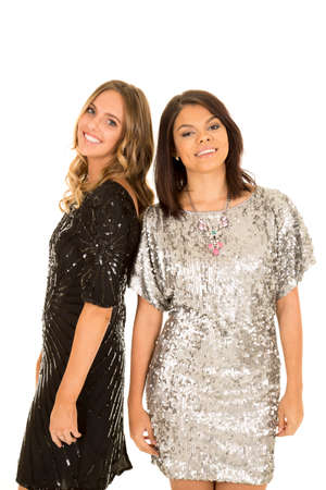 Two woman in their party dresses standing together with smiles.の写真素材