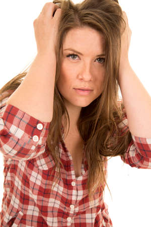 a woman with a sensual expression on her face, with her hands in her hair.の写真素材