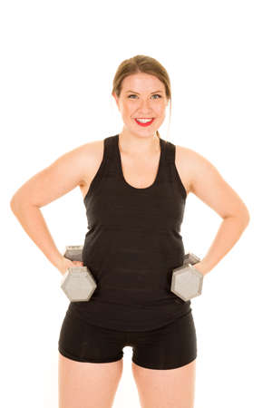 A woman with a smile on her face, holding on to the weights on her hips.の写真素材