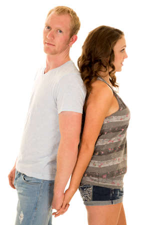 A man and woman with their backs together holding hands.の写真素材