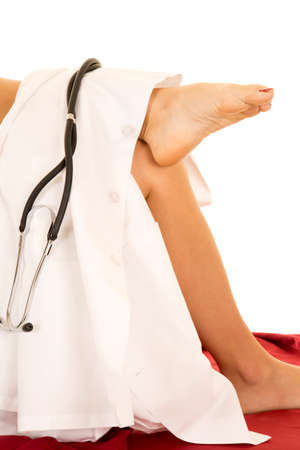 a woman's legs with a white lab coat with a stethoscopeの写真素材