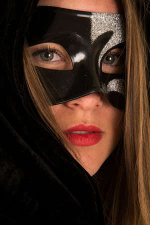 A close up of a woman in her black cloak and a mask.の写真素材
