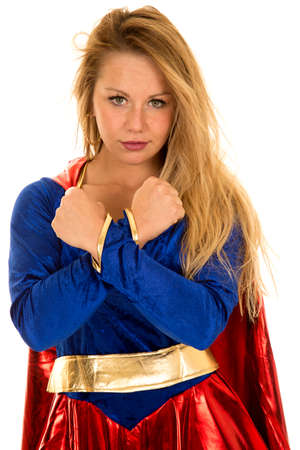 A woman in her super hero costume with a serious expression with her wrists crossed.の写真素材
