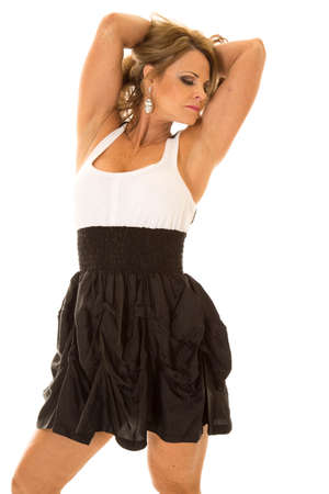 a mature woman in her formal dress with her arms up by her head, with a serious expression.の写真素材