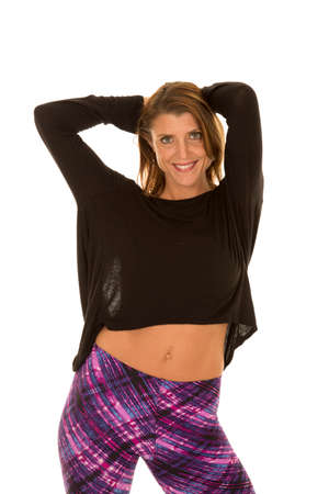 A woman in her purple leggings with her arms up.の写真素材