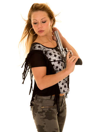 a woman with  a pistol in her hands and the wind blowing her hair.の写真素材