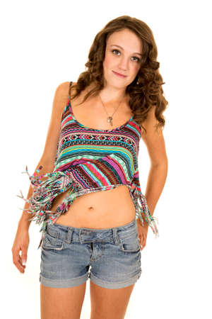 A woman in her colorful tank top and jean shorts with a small smile on her lips.の写真素材