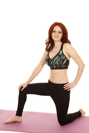a woman in her fitness clothing kneeling and stretching.の写真素材
