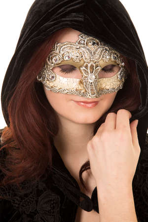 A close up of a woman in her black cape and mask with her eyes closed.の写真素材
