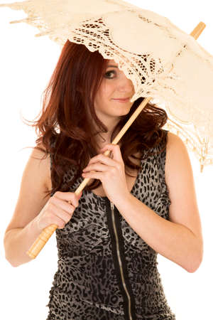 A woman in her printed dress hiding her face with an umbrella.の写真素材