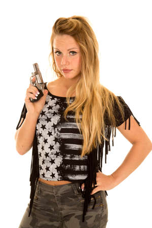a woman with a serious expression on her face, holding on to a pistol.の写真素材