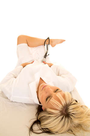 a woman doctor with her leg up in her lab coat and a stethoscope.の写真素材