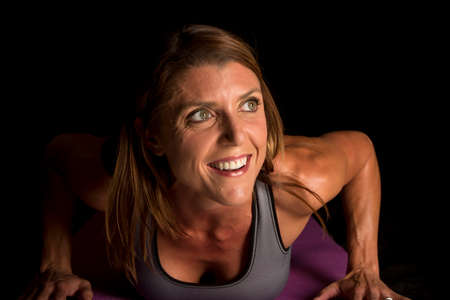 A woman in her gray sports bra doing a push up
