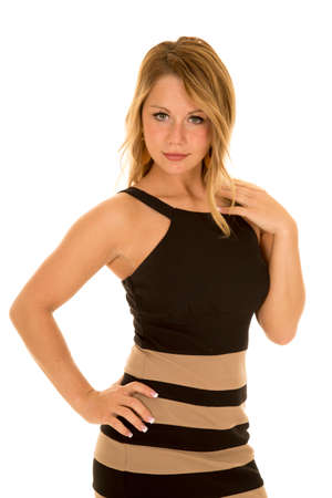 A woman with her hand on her hip looking in her tan and black striped dress.の写真素材