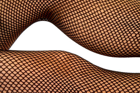 A close up shot of a womans legs in black fishnet stockings.の写真素材