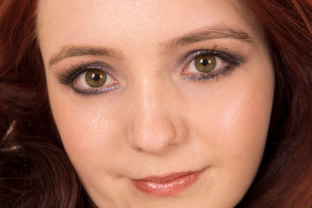 A close up of a woman with red hair, looking.の写真素材