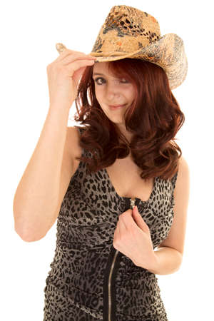 a woman in her printed dress touching her zipper, wearing her western hat.の写真素材
