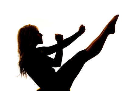 A silhouette of a woman doing an ab workout on a white background.の写真素材