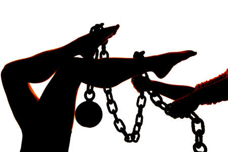 a silhouette of a woman's legs getting tied up with a chain.の写真素材