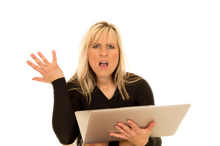 a woman with a frustrated expression on her face, holding on to her laptopの写真素材