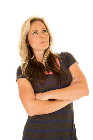 a woman in her dress with her arms folded looking up with a serious expression.の写真素材