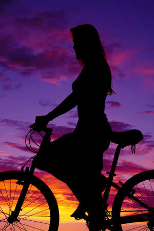 a silhouette of a woman on her bike, riding for the pleasure of it.
