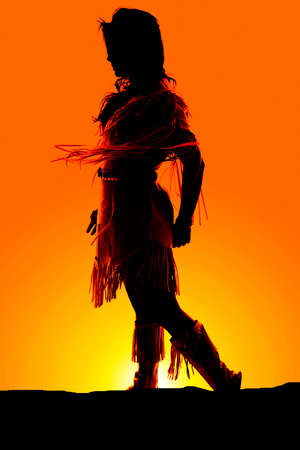 a silhouette of a Native American walking in the sunrise.の写真素材