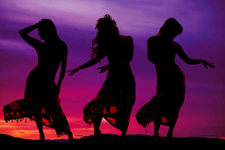 Three women in their sarongs dancing in the outdoorsの写真素材