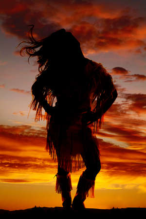 a silhouette of a woman in her Indian clothing with the wind blowing her hair.の写真素材