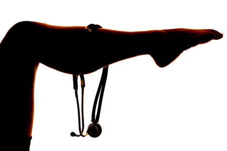 a silhouette of a woman with her legs up with a doctors stethoscope on her calf.の写真素材