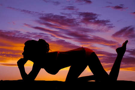 A silhouette of a woman on the ground in her bikini.の写真素材