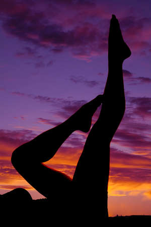 a silhouette of a woman's legs in the outdoors laying flat.の写真素材