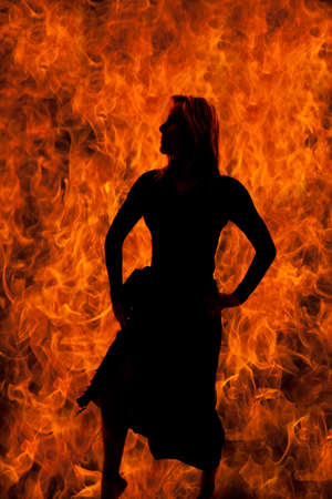 A silhouette of a woman in her sarong with a flame background.の写真素材