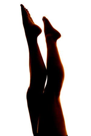 A silhouette of a woman's legs pointing up to the sky.の写真素材
