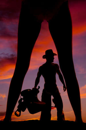 A silhouette of a woman with her legs wide, and her cowboy showing through them.の写真素材
