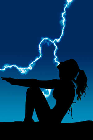 a silhouette of a woman sitting reaching out and relaxing.の写真素材