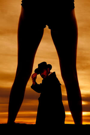 a silhouette of a woman's legs with a cowboy inbetween her legs.の写真素材